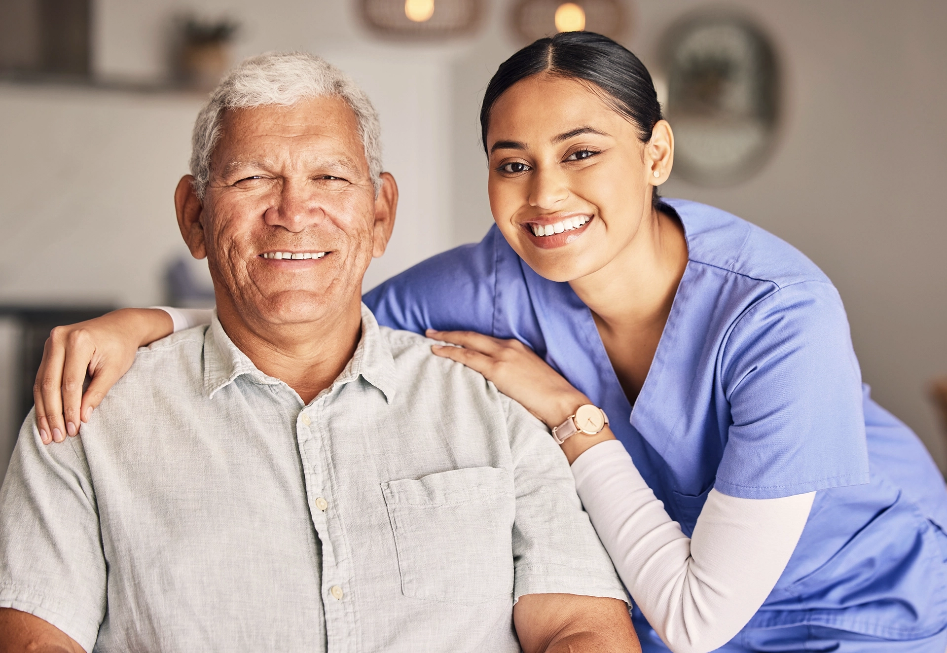 In-home care aide smiling while providing personal care to a senior