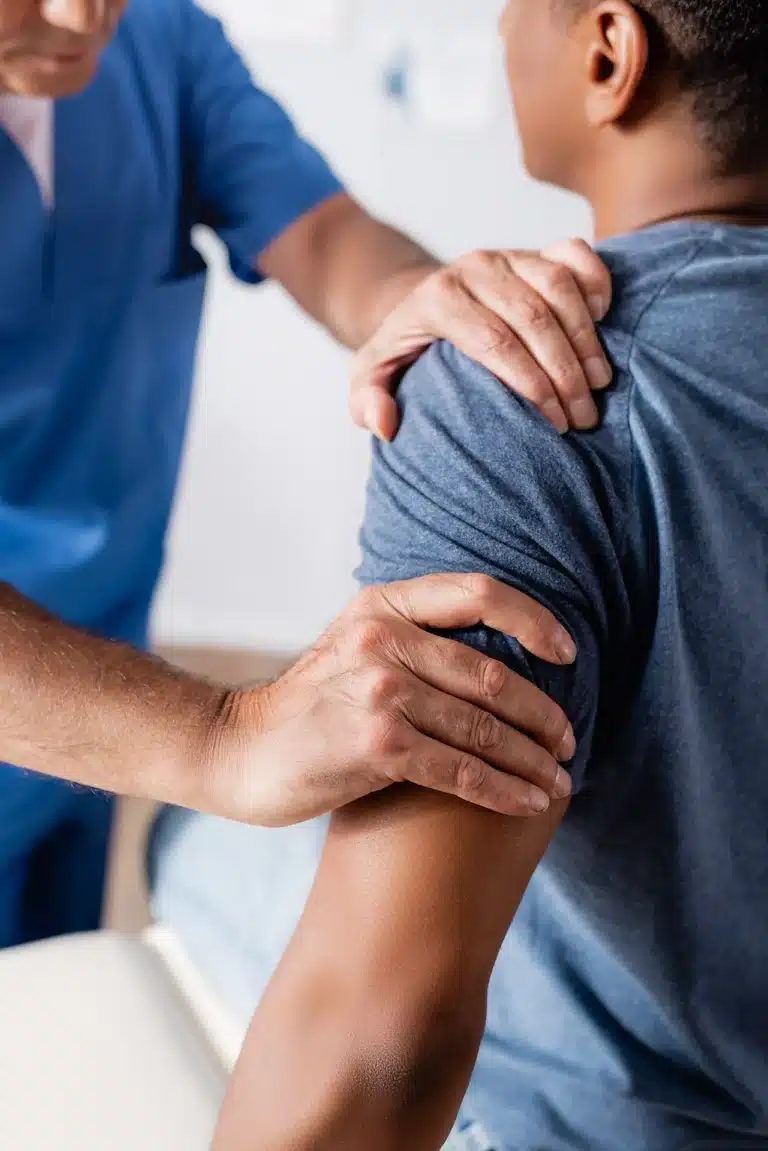 Physical therapist assisting patient with shoulder rehabilitation exercises at home