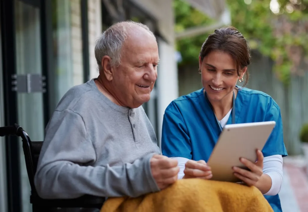 Care worker showing information on a tablet to a patient in Miami Lakes, FL