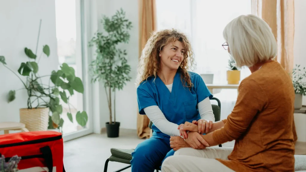 Healthcare worker holding the hands of an adult during a home visit in Central & Southern Florida