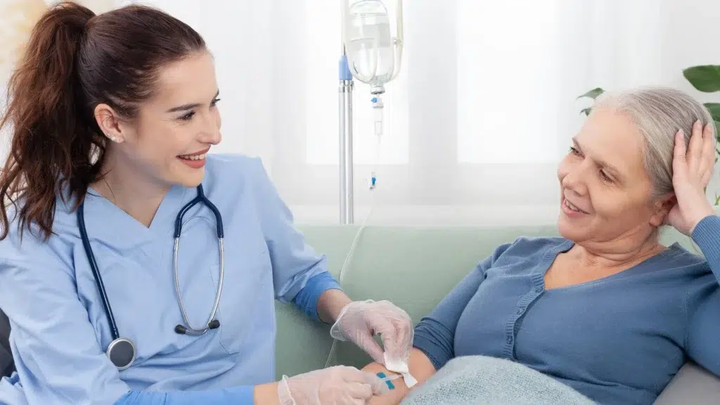 Home healthcare worker adjusting an IV line for an older patient in Central & Southern Florida