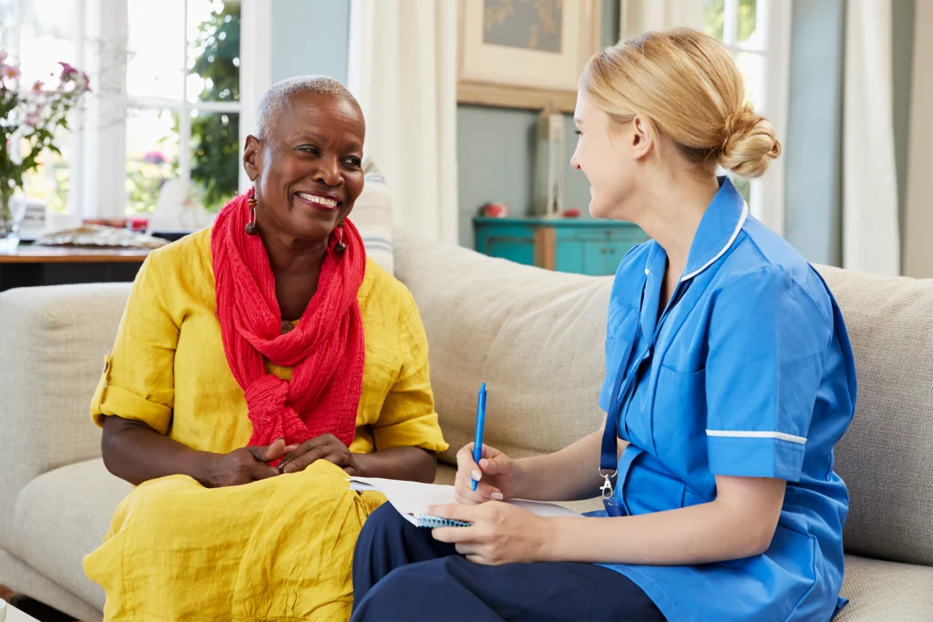 Caregiver discussing 24-hour home care options with an older woman in her home.