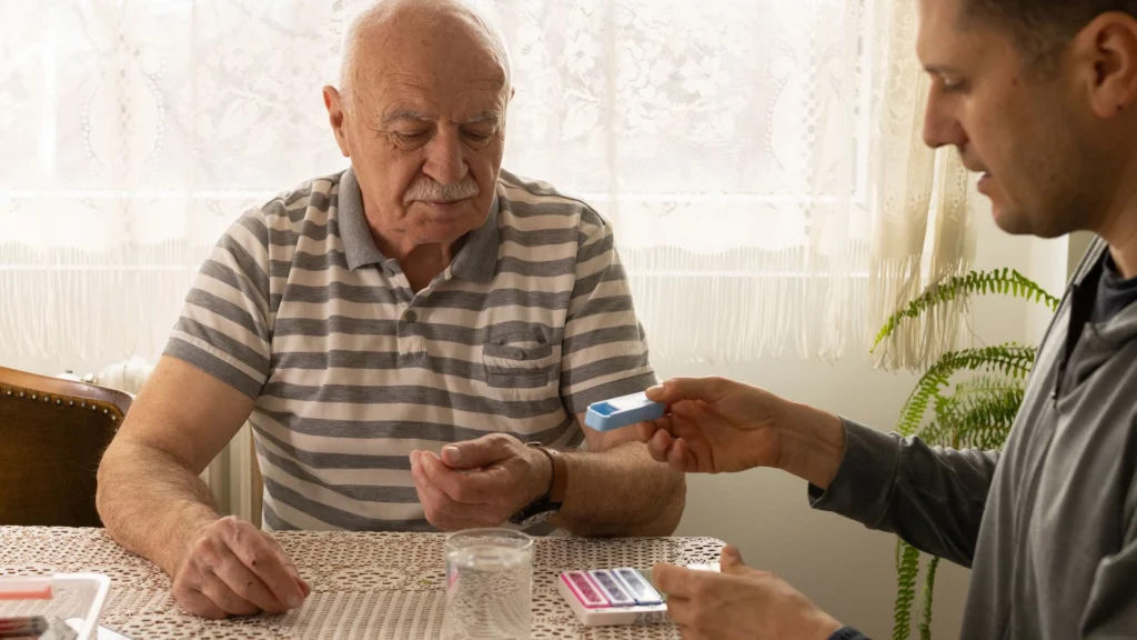 Caregiver handing a pill organizer to an elderly person in Central & Southern FL