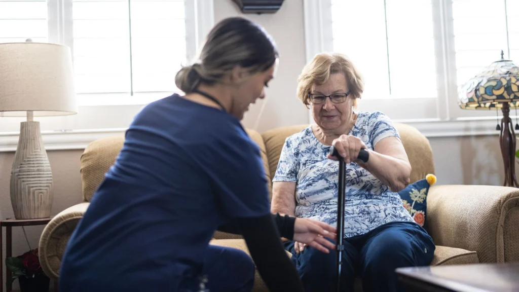 Healthcare worker assisting an elderly person with a walking stick at home in Tampa, FL