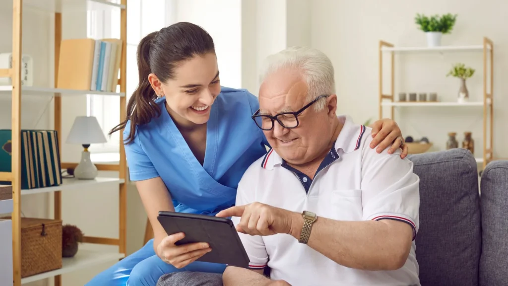 Neurological home caregiver assisting an older adult with a tablet in Central & Southern Florida
